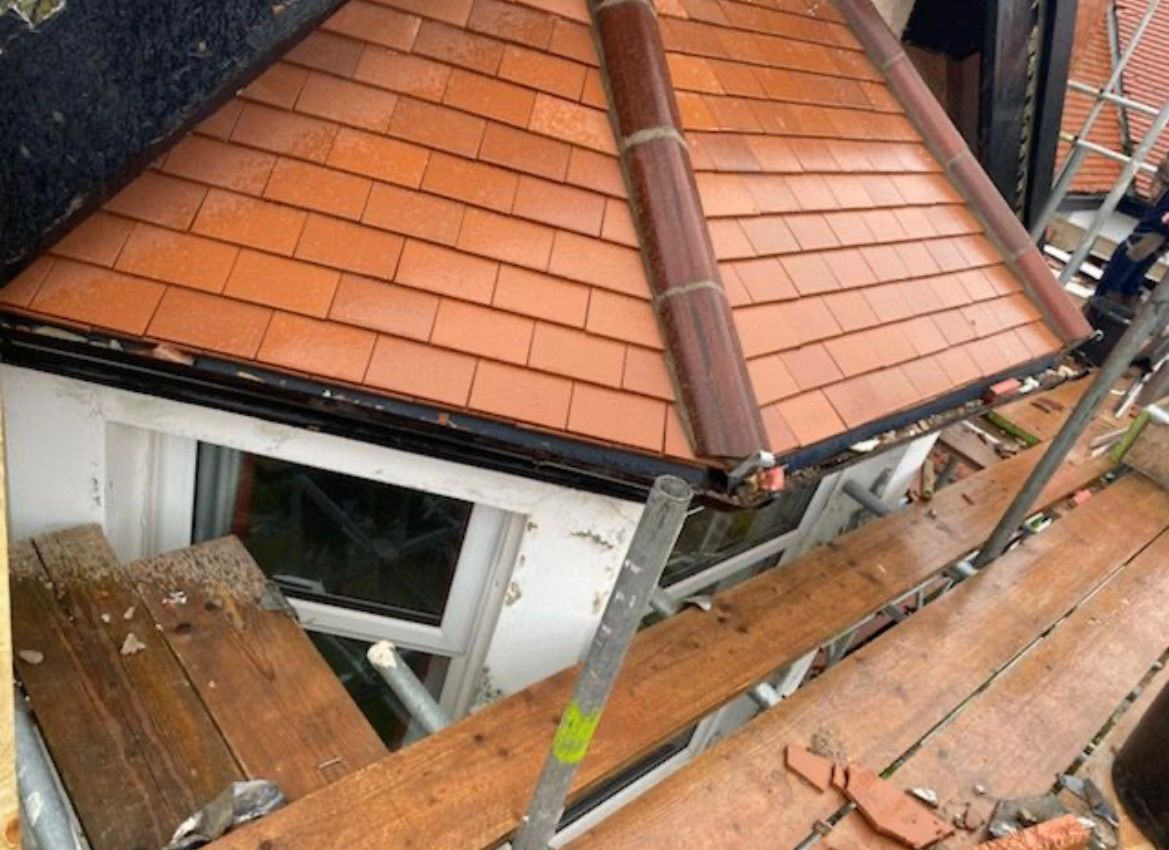 New red clay tiled bay roof with ridge tiles completed on a residential re-roofing project