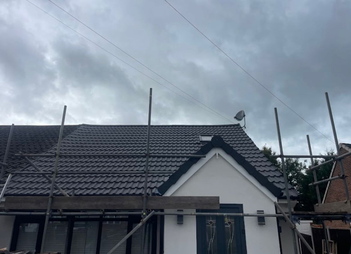 Completed grey pantile pitched roof on an Essex bungalow with scaffolding still in place after a full re-roof